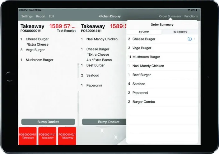 The kitchen display on an iPad: two takeaway dockets listing their items and modifiers, with a bump control, beside an order summary.